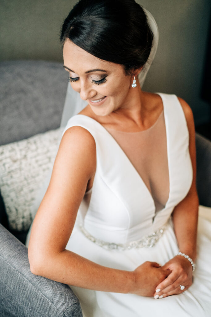 portrait of bride sitting and looking down at shoulder