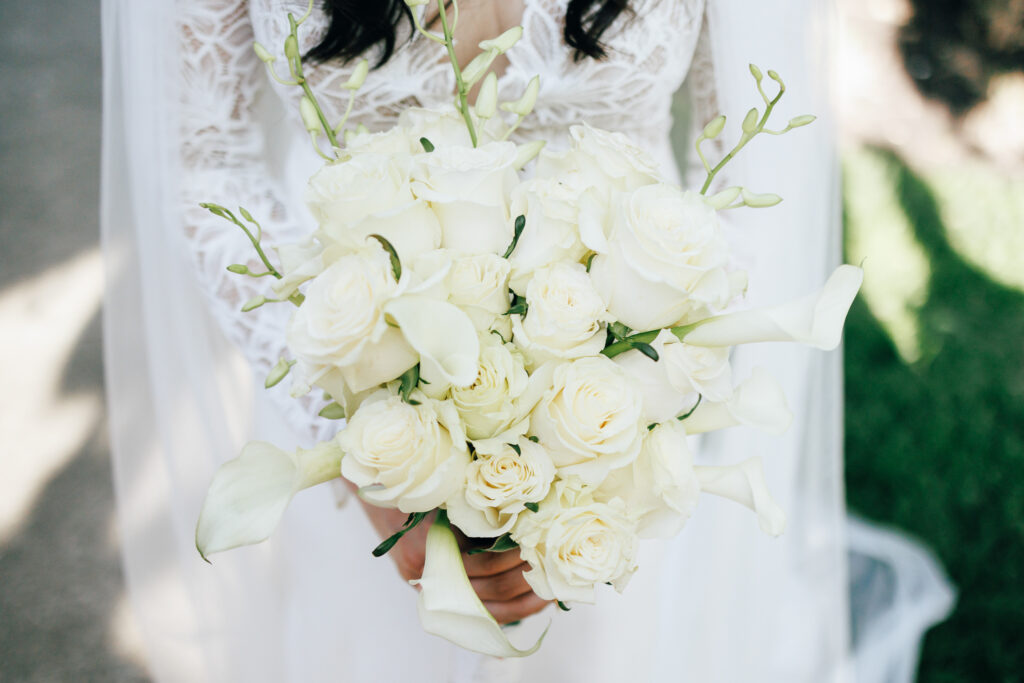 bride holding all white wedding bouquet