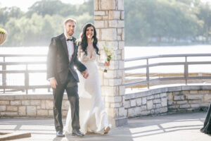 bride and groom walk into wedding reception in sunshine