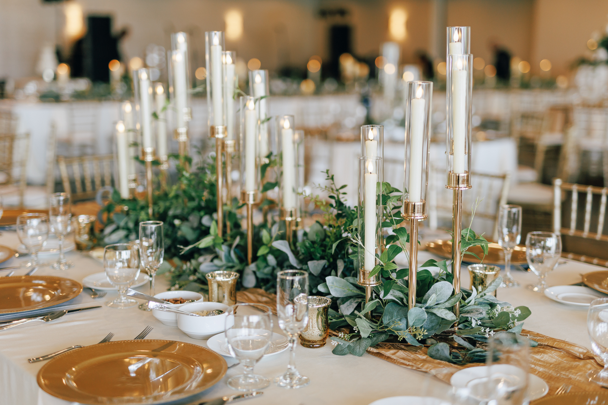 wedding reception tablescape full of gold candlesticks