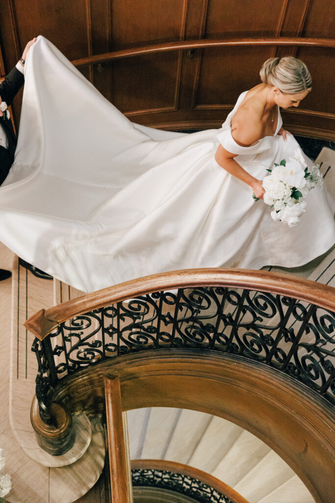 bride walking up spiral staircase