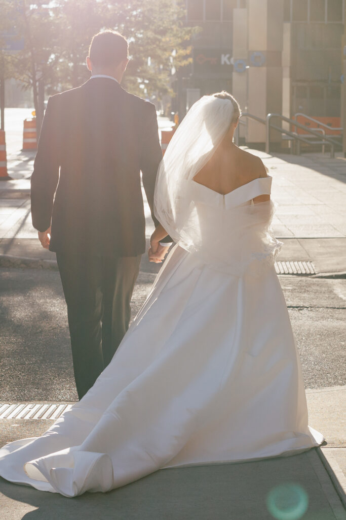 bride and groom walking away from the camera in sunset light