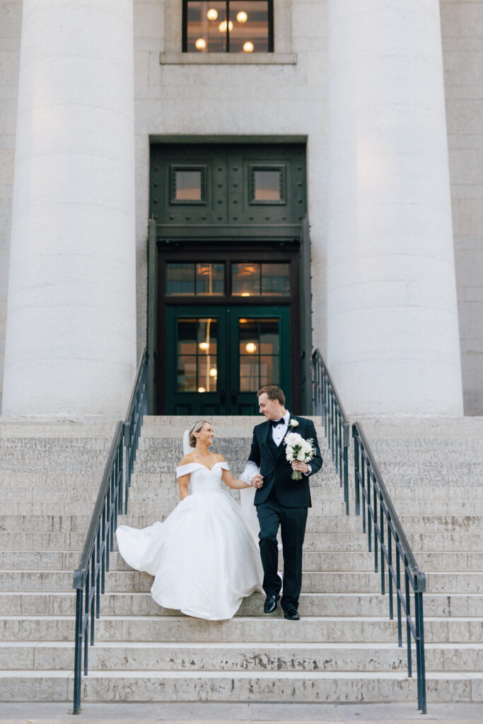 bride and groom descending marble staircase