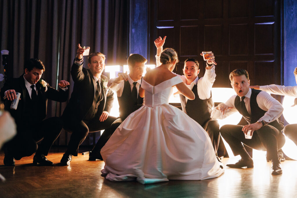 bride dancing with groomsmen on dancefloor