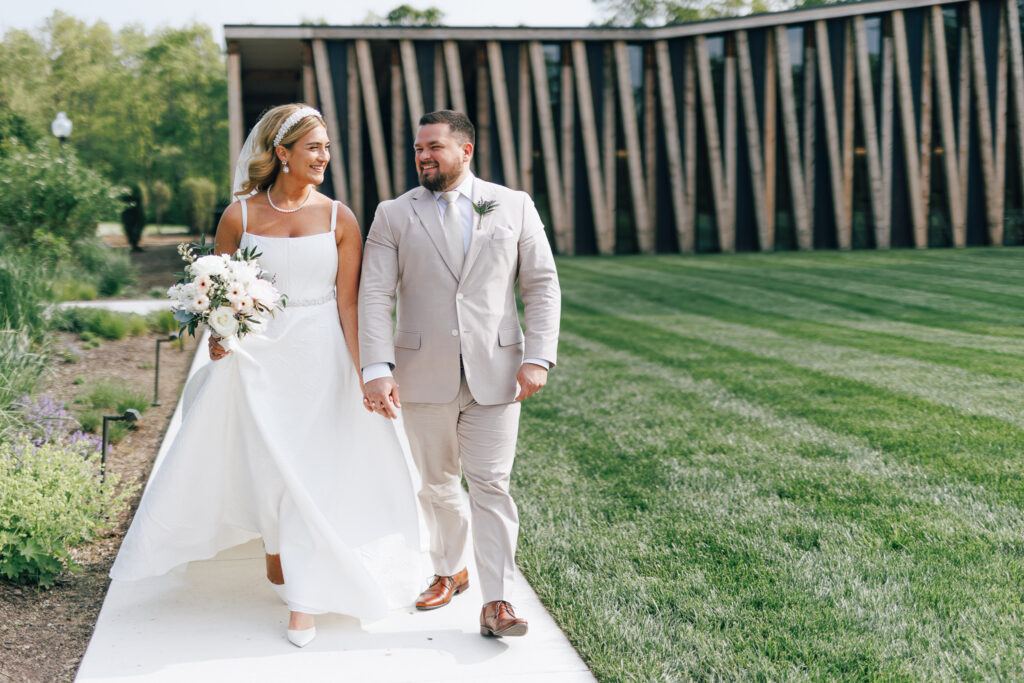 Bride and Groom walking infront of Modern event space at Jorgensen Farms Columbus