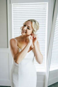 bride getting ready putting earing on