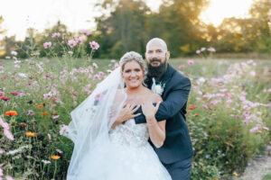 Bride and groom standing in field of Wild Flowers at Jorgensen Farms in Columbus