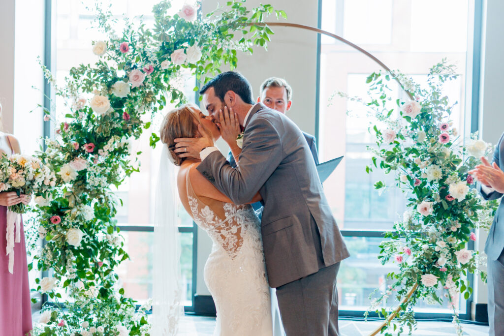 wedding kiss infront of floral arch at Le Meridian Hotel