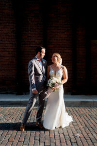 bride and groom in ally looking at each other