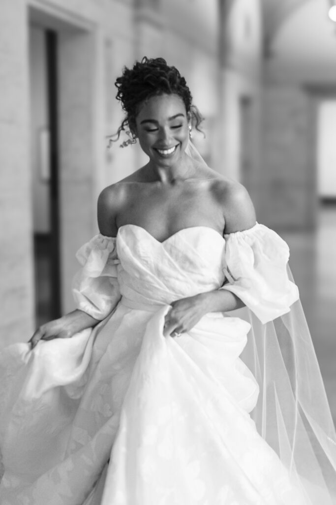 Bride in black and white ball gown with puff sleeves running down art gallery hallway at the Columbus Museum of Art wedding venue
