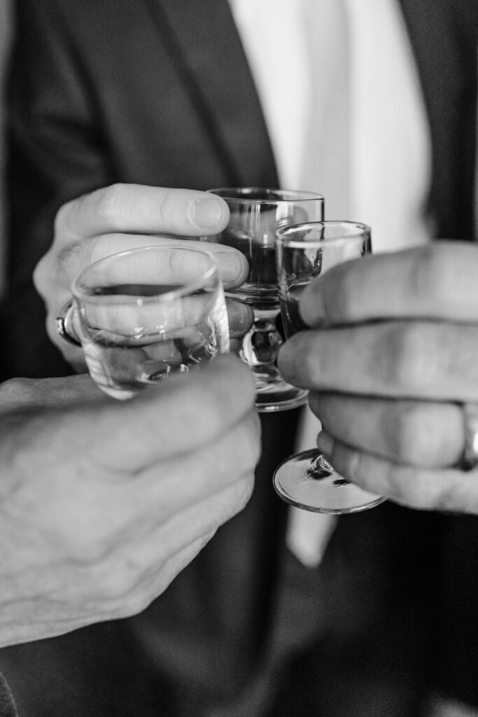 groom toasting whiskey with dads at the leveque hotel