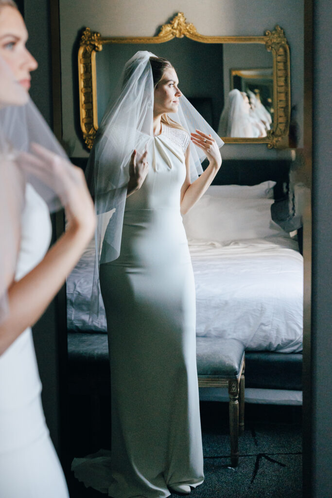 bride infront of mirror in getting ready room before wedding The LeVeque Hotel