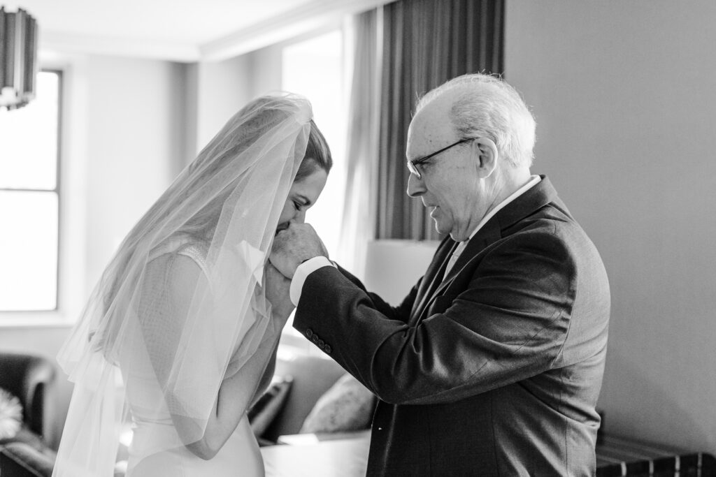 bride kisses her dads hands before walking down the aisle in columbus ohio