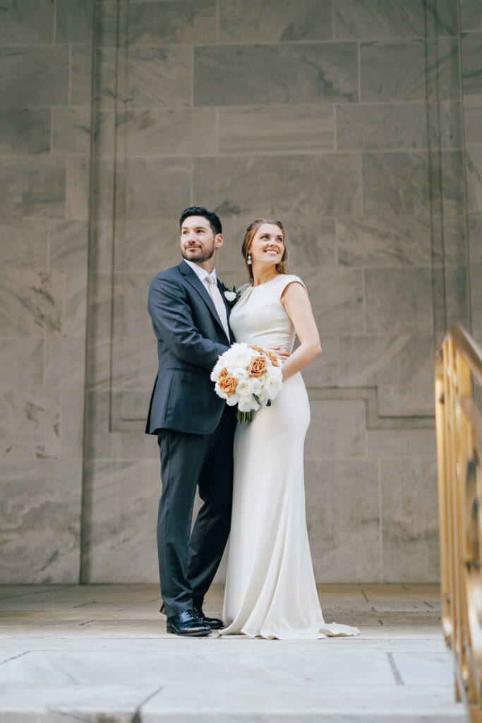 bride and groom pose infront of leveque hotel