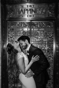 bride and groom laugh and snuggle infront of golden door at the leveque hotel